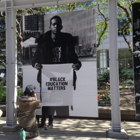 Man repairing slashed Black Education Matters photo