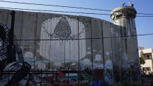 Israel security wall with painting of a Christmas tree surrounded by the wall